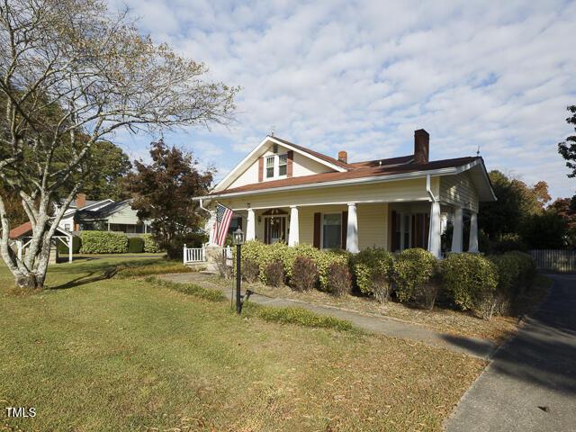 715 E Broad St, Fuquay Varina, NC 27526 - view of side of home featuring a chimney, covered porch, and a lawn