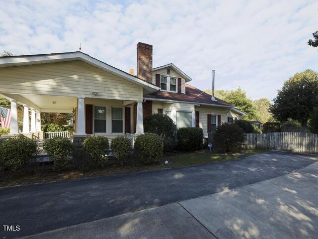 715 E Broad St, Fuquay Varina, NC 27526 - view of property exterior with a chimney, covered porch, and fence