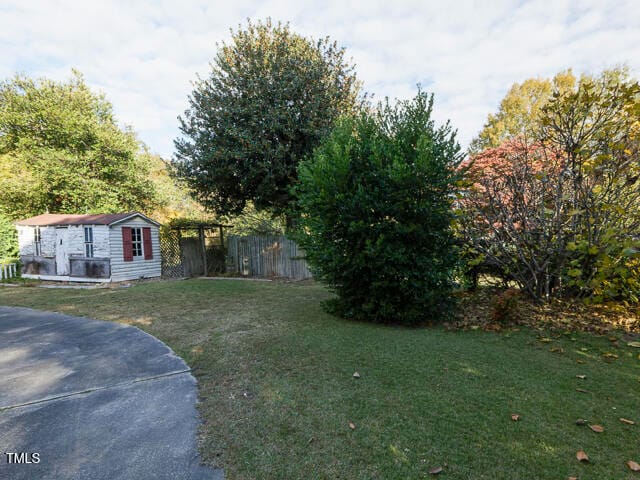 view of front of property featuring a front lawn and an outbuilding