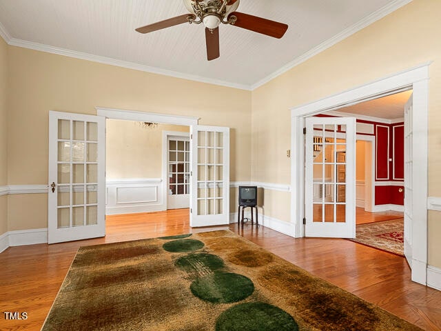 empty room with french doors, hardwood / wood-style flooring, and crown molding