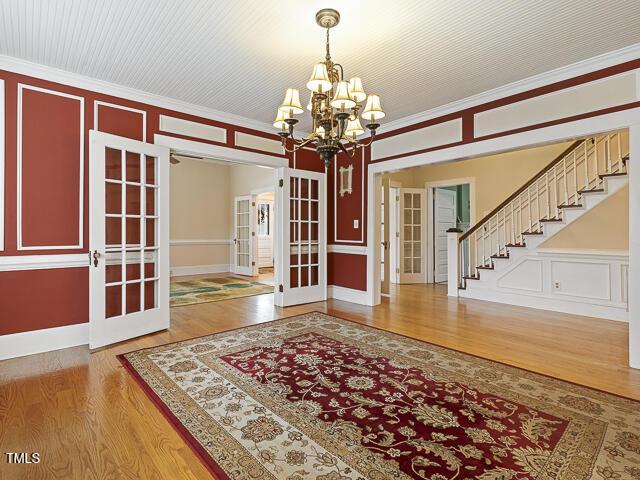 715 E Broad St, Fuquay Varina, NC 27526 - entrance foyer featuring french doors, a chandelier, wood finished floors, stairway, and ornamental molding