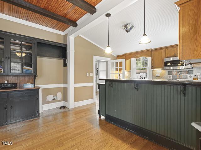 715 E Broad St, Fuquay Varina, NC 27526 - kitchen featuring a breakfast bar, pendant lighting, light wood-style floors, tasteful backsplash, and a peninsula