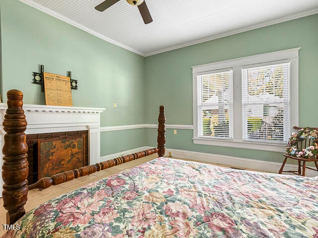 tiled bedroom featuring ornamental molding and ceiling fan