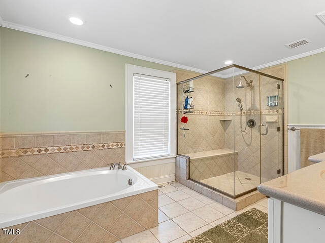 bathroom with ornamental molding, vanity, separate shower and tub, and tile patterned floors