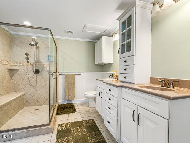 bathroom with vanity, toilet, an enclosed shower, and crown molding