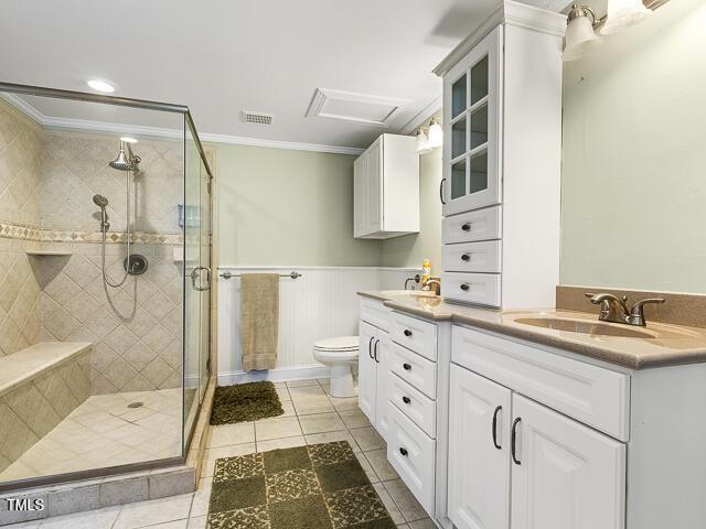 715 E Broad St, Fuquay Varina, NC 27526 - bathroom featuring ornamental molding, toilet, a stall shower, tile patterned flooring, and double vanity