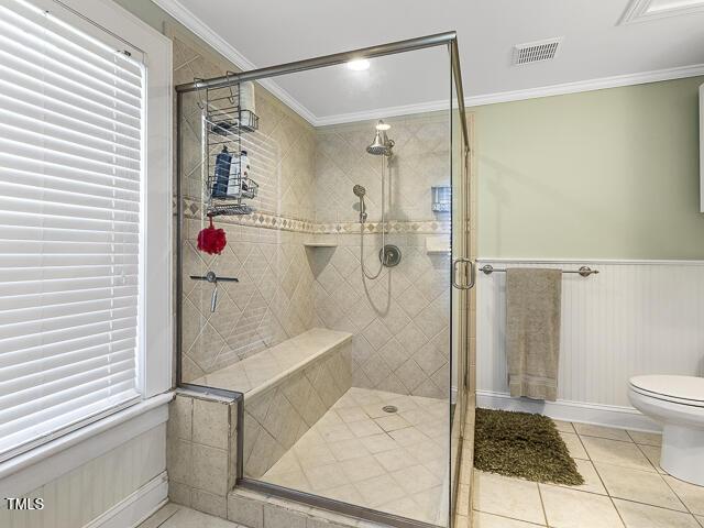 715 E Broad St, Fuquay Varina, NC 27526 - bathroom with tile patterned flooring, a stall shower, toilet, crown molding, and wainscoting