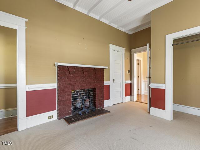 715 E Broad St, Fuquay Varina, NC 27526 - unfurnished living room featuring carpet floors, a brick fireplace, and baseboards