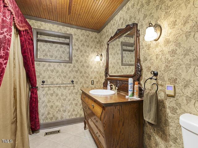 715 E Broad St, Fuquay Varina, NC 27526 - bathroom featuring wallpapered walls, tile patterned flooring, wooden ceiling, vanity, and ornamental molding