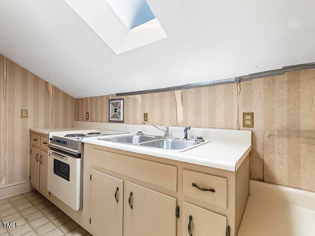 kitchen featuring a skylight, sink, light tile patterned floors, and white electric range oven