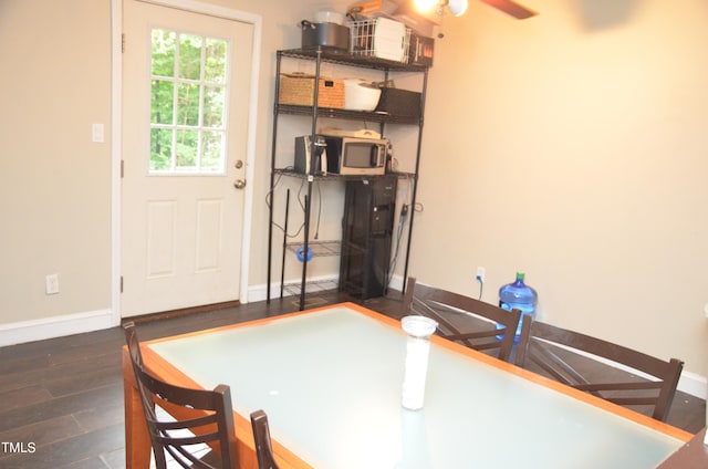 unfurnished dining area with ceiling fan and dark wood-type flooring