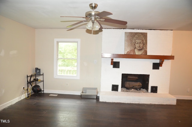 unfurnished living room with ceiling fan, a fireplace, and dark wood-type flooring