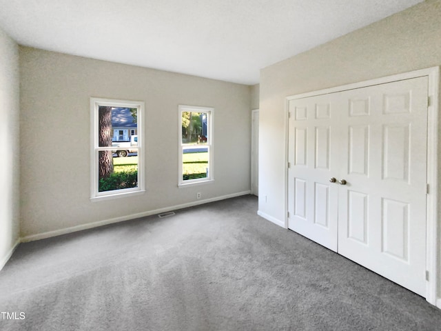 unfurnished bedroom with carpet flooring and a closet