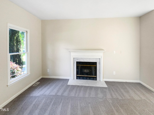 unfurnished living room featuring carpet and a high end fireplace