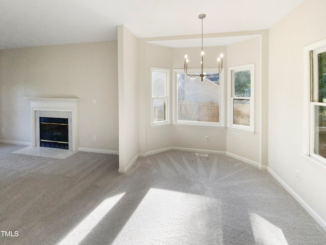 unfurnished living room with a premium fireplace, light carpet, and a chandelier