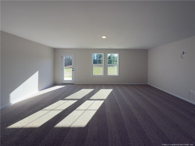 carpeted spare room featuring baseboards