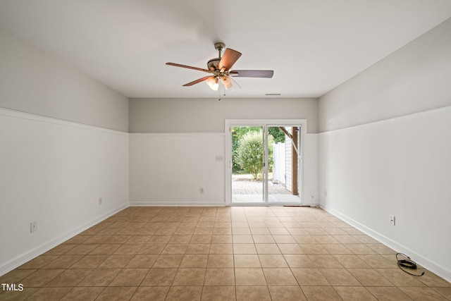 spare room with ceiling fan and light tile patterned floors