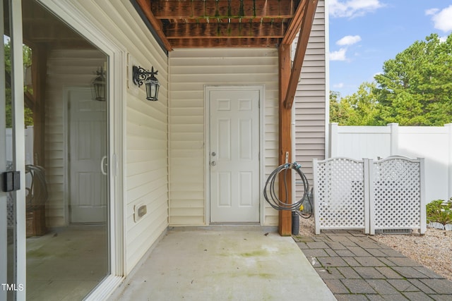 view of exterior entry with a patio area