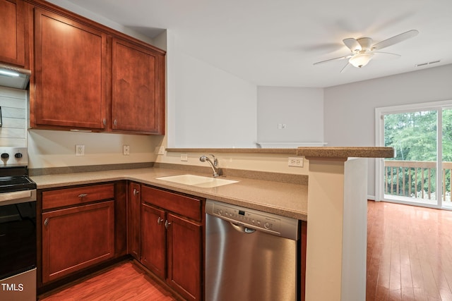 kitchen featuring sink, kitchen peninsula, electric range oven, stainless steel dishwasher, and light hardwood / wood-style flooring