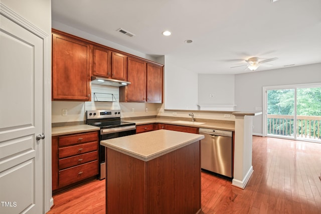 kitchen featuring ceiling fan, sink, a kitchen island, light hardwood / wood-style flooring, and stainless steel appliances