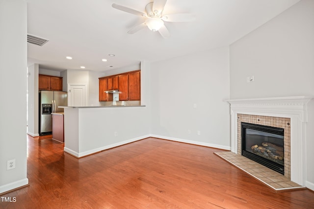 unfurnished living room with a fireplace, hardwood / wood-style floors, and ceiling fan