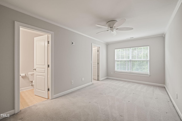 unfurnished bedroom featuring light carpet, ensuite bath, crown molding, and ceiling fan