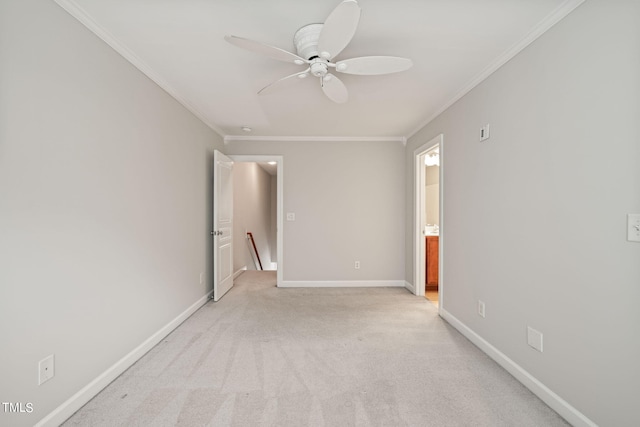 spare room with ceiling fan, light colored carpet, and crown molding