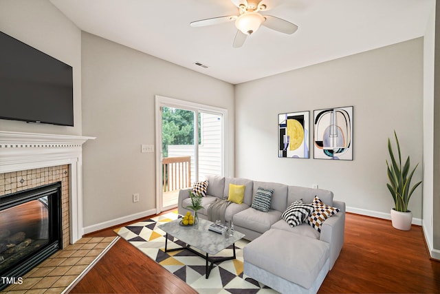 living room with a fireplace, light hardwood / wood-style floors, and ceiling fan