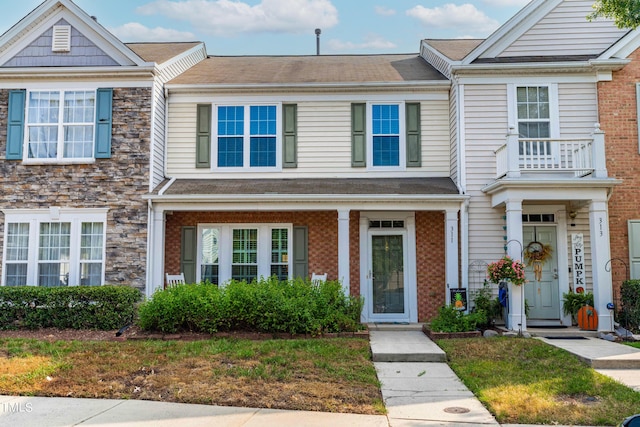 townhome / multi-family property with brick siding and stone siding