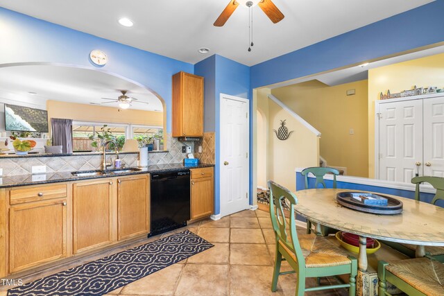 kitchen with dishwasher, sink, decorative backsplash, ceiling fan, and dark stone counters