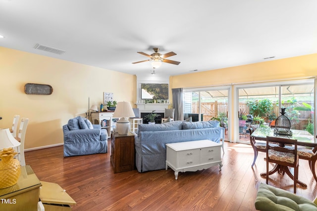 living room featuring ceiling fan and dark hardwood / wood-style flooring