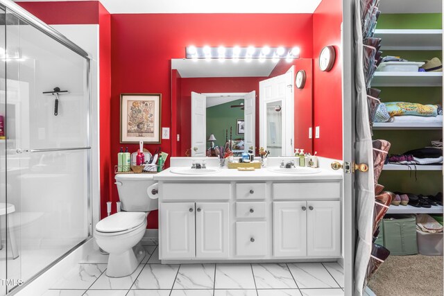 bathroom featuring vanity, toilet, and a shower with shower door