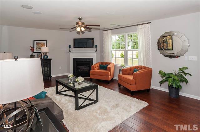 living room featuring dark wood-type flooring and ceiling fan