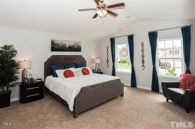 bedroom featuring lofted ceiling, ceiling fan, and light carpet