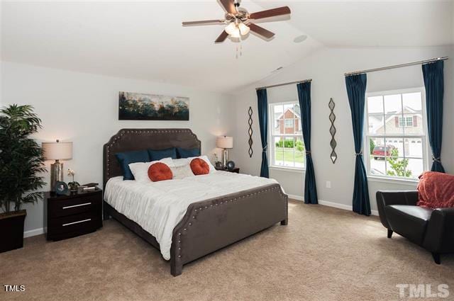 bedroom with light carpet, ceiling fan, baseboards, and vaulted ceiling