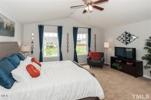 carpeted bedroom featuring lofted ceiling and ceiling fan