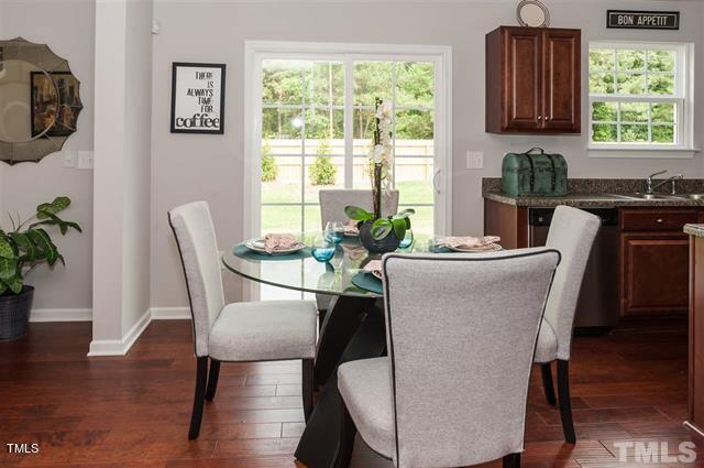 dining space featuring a healthy amount of sunlight, dark wood-type flooring, and baseboards