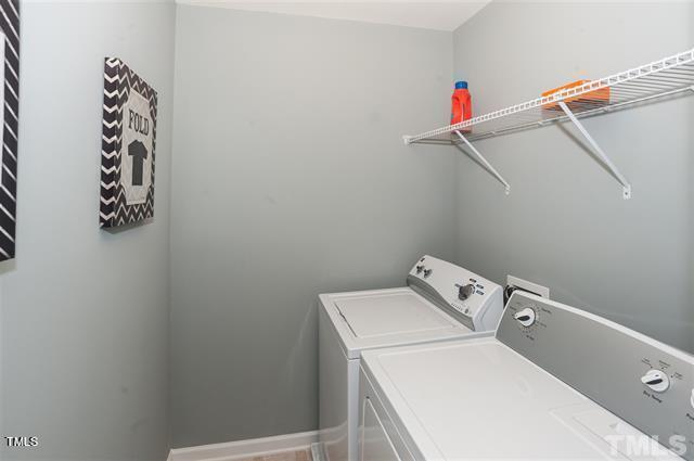 washroom featuring baseboards, separate washer and dryer, and laundry area