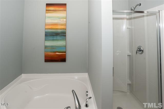 bathroom featuring a shower stall and a garden tub