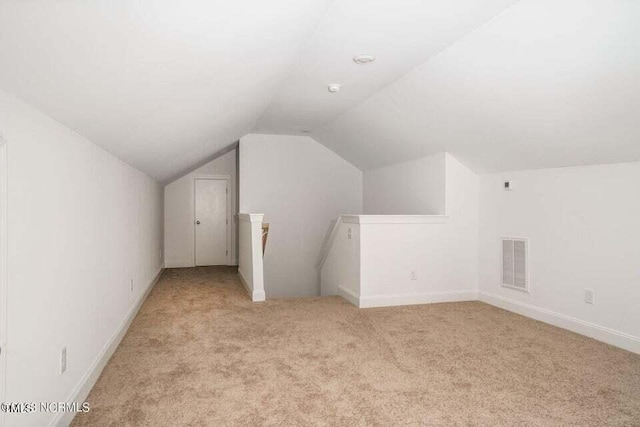 additional living space with lofted ceiling and light carpet