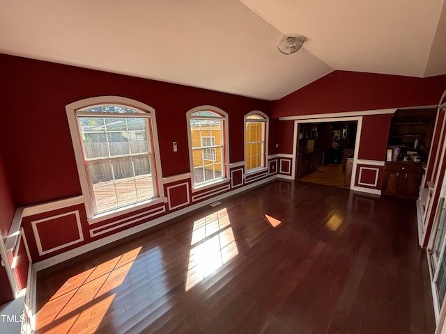 interior space featuring lofted ceiling and dark hardwood / wood-style flooring