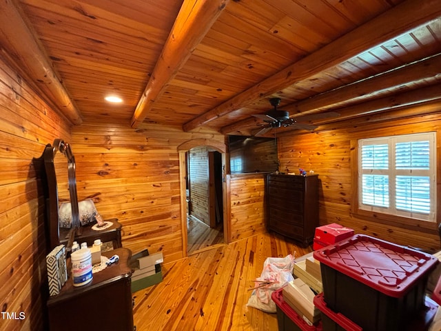 unfurnished bedroom with wooden ceiling, beam ceiling, hardwood / wood-style flooring, and wooden walls