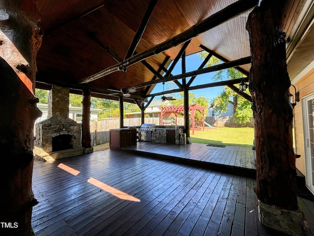 wooden deck featuring ceiling fan, grilling area, a yard, and a hot tub