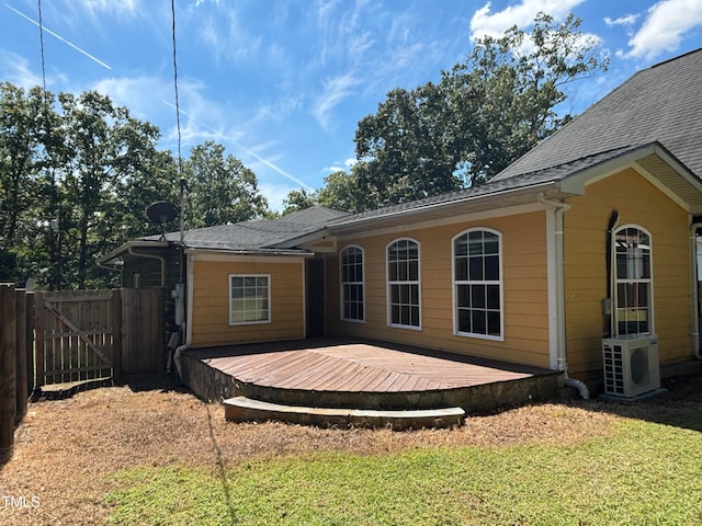 exterior space featuring ac unit, a wooden deck, and a lawn