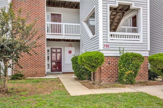 entrance to property with a yard and a balcony