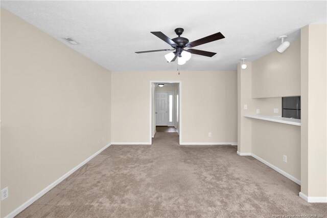 spare room featuring light colored carpet and ceiling fan