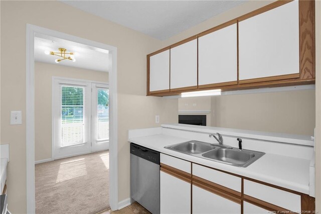 kitchen with dishwasher, a chandelier, light carpet, white cabinetry, and sink