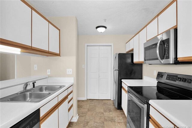 kitchen featuring white cabinets, stainless steel appliances, a textured ceiling, and sink