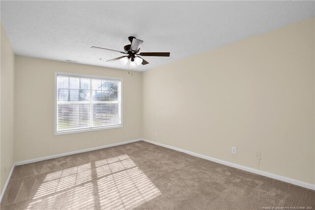 carpeted spare room featuring a textured ceiling and ceiling fan