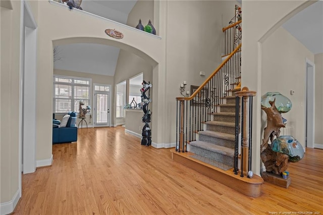 entrance foyer featuring light wood-type flooring and high vaulted ceiling